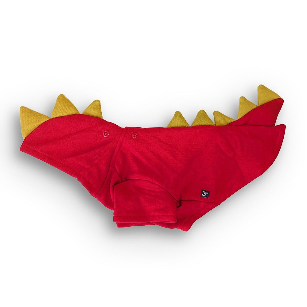 A red baby diaper cover or underwear with yellow dinosaur-style spikes along the back, laid flat on a white background.