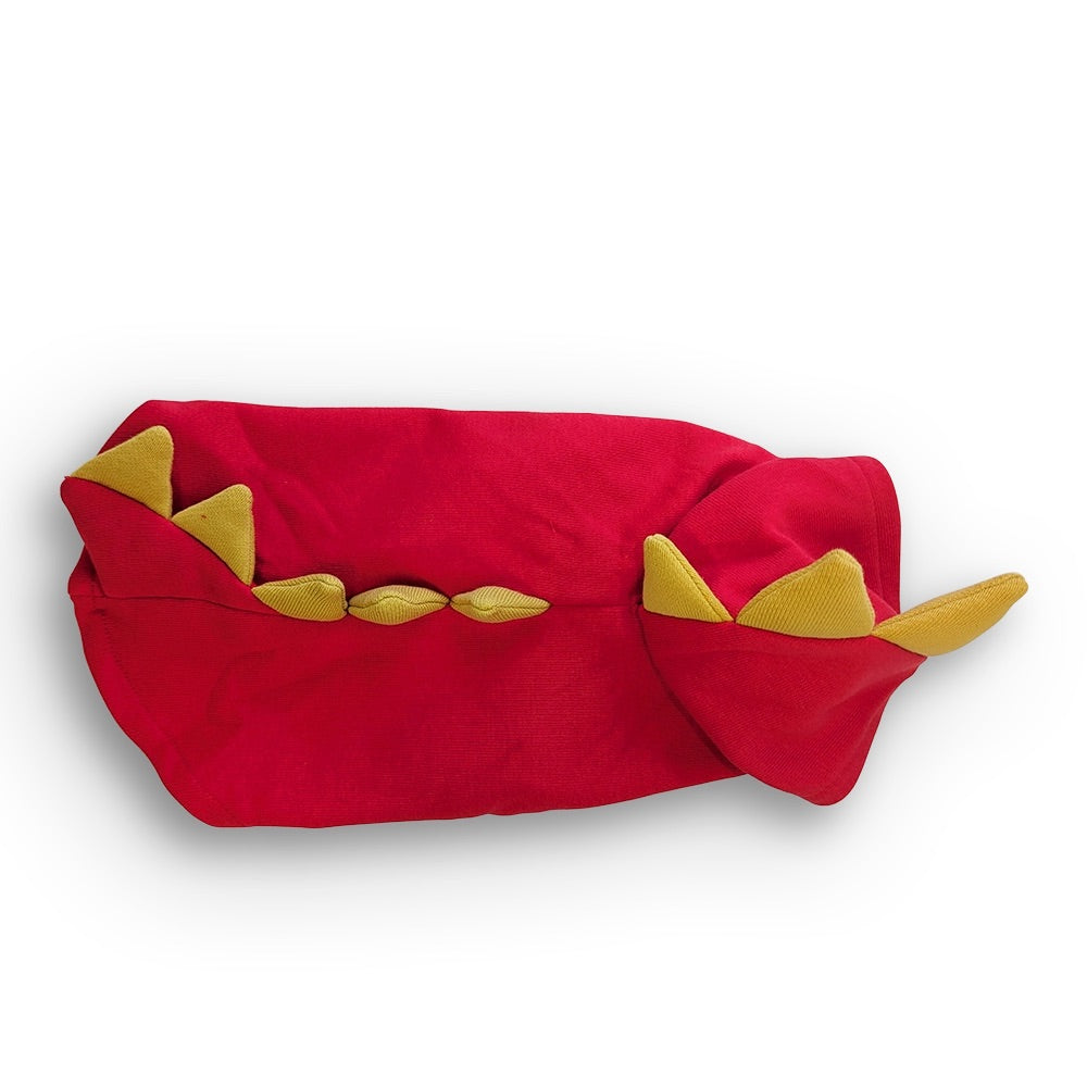 A red plush toy or cushion with yellow dragon-like teeth details, photographed on a clean white background.