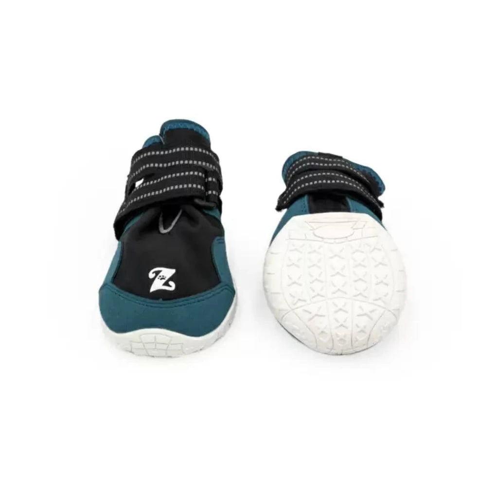 Pair of teal and black dog adventure boots with white soles on a white background