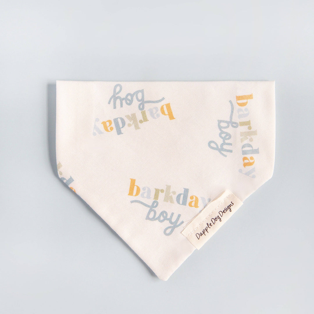 Dapple Dog Designs Barkday Boy over-the-collar dog bandana featuring a soft birthday print in blue, gray, and gold tones.