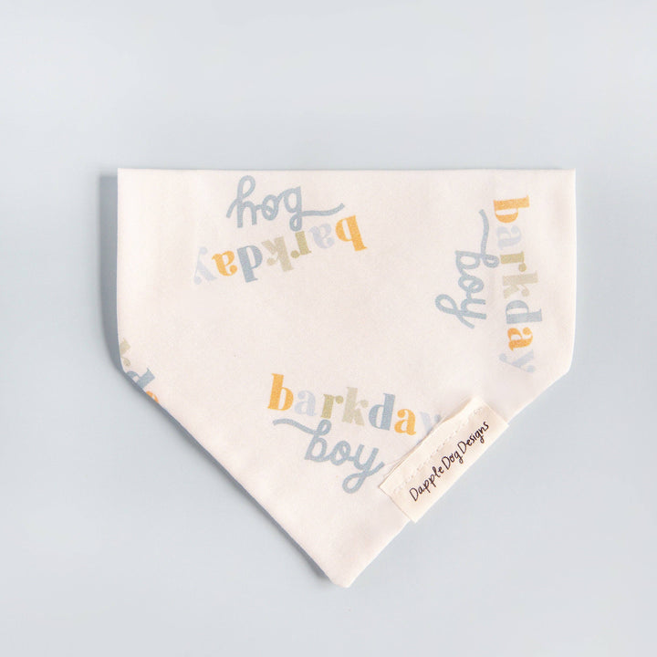 Dapple Dog Designs Barkday Boy over-the-collar dog bandana featuring a soft birthday print in blue, gray, and gold tones.
