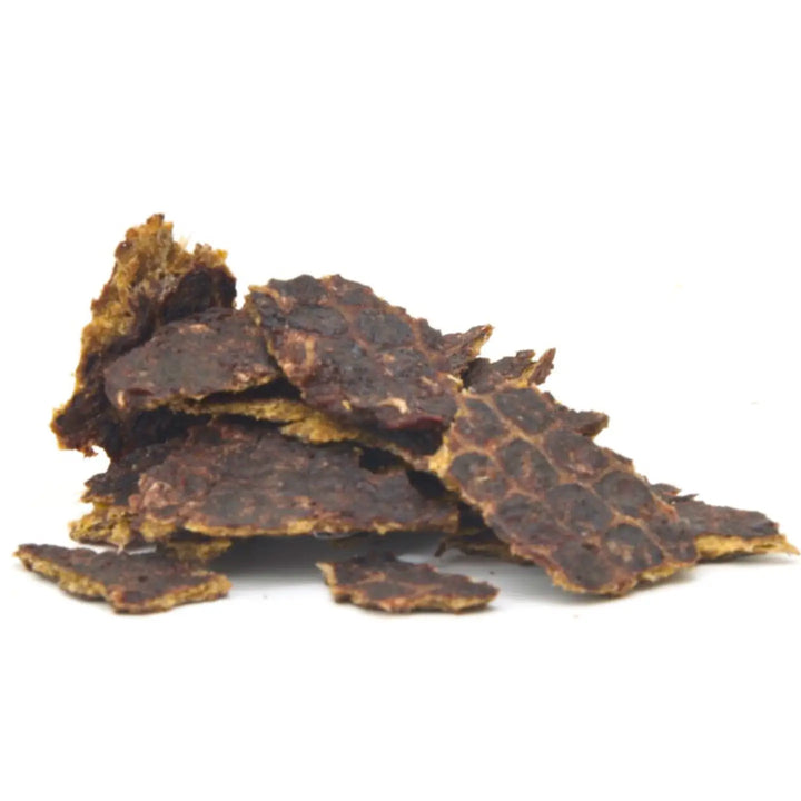 Dried beef jerky pieces on a white background