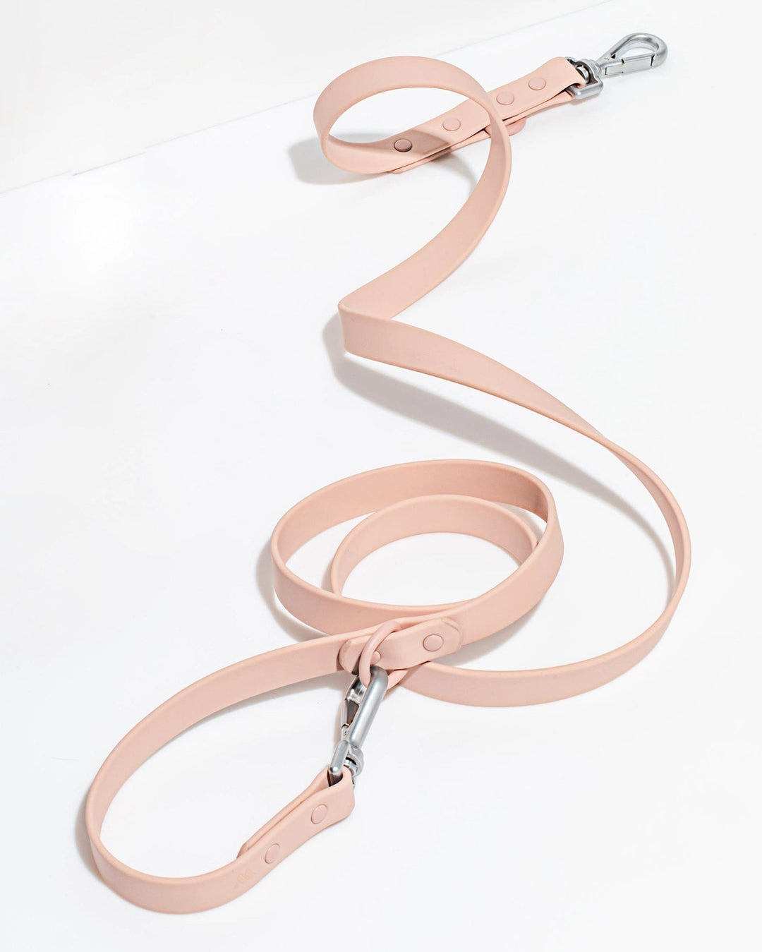 Pink dog leash with a metal clip on a white background