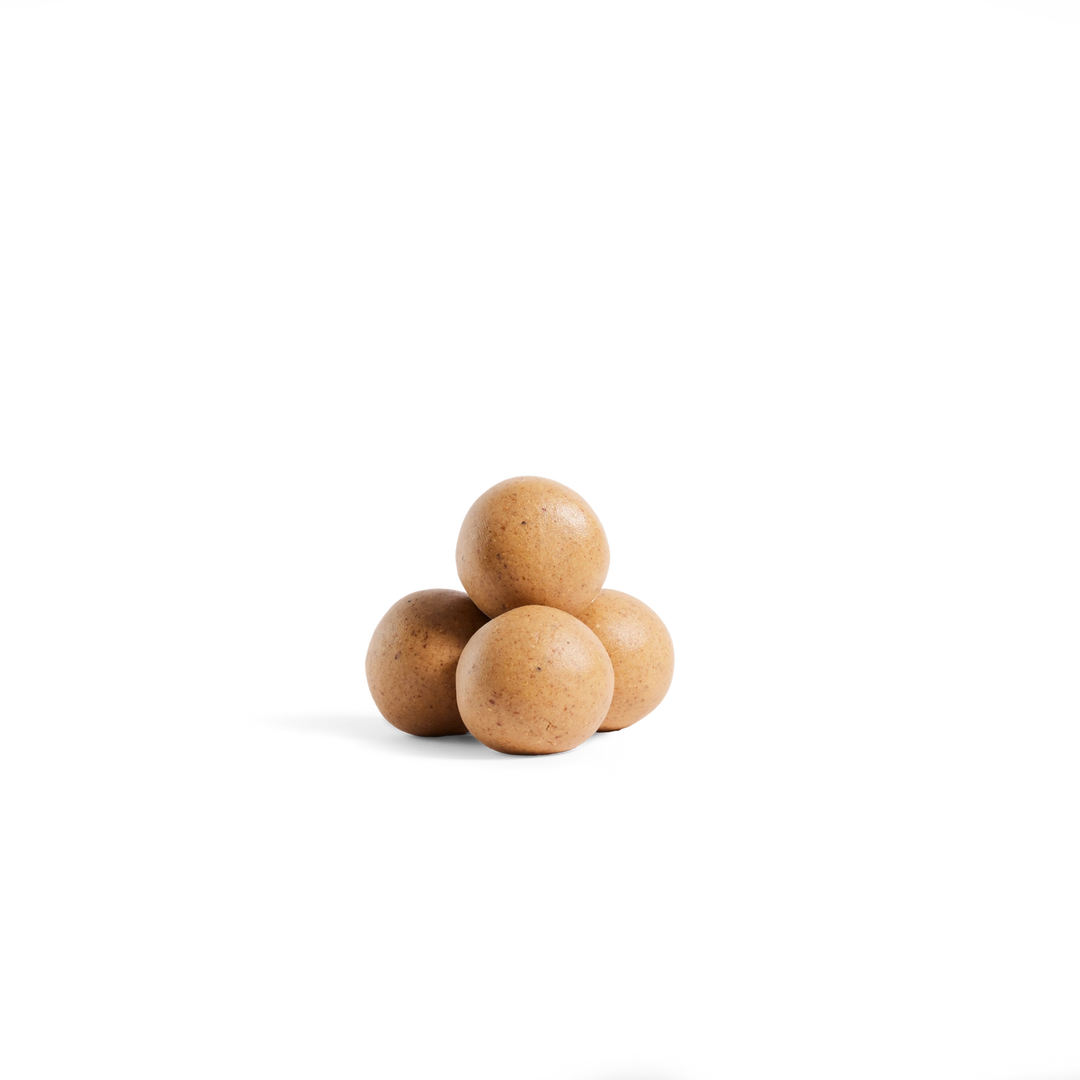 Four small round brown objects stacked in a pyramid on a plain white background.