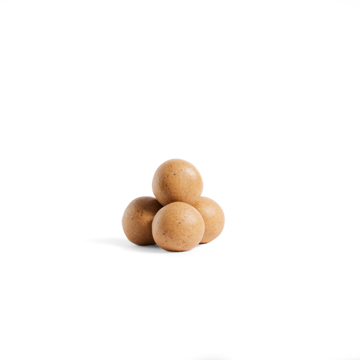 Four small round brown objects stacked in a pyramid on a plain white background.