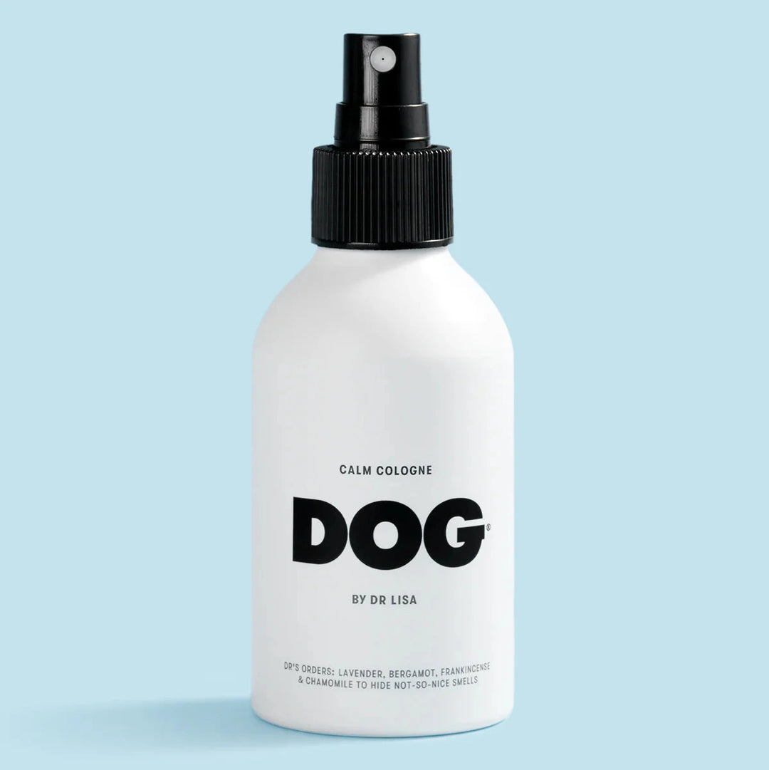White spray bottle labeled 'DOG' on a light blue background