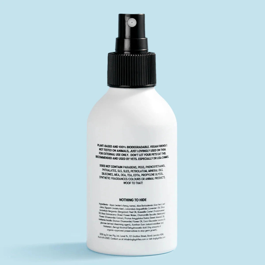 Back of Calm Cologne dog spray bottle with black nozzle on a light blue background