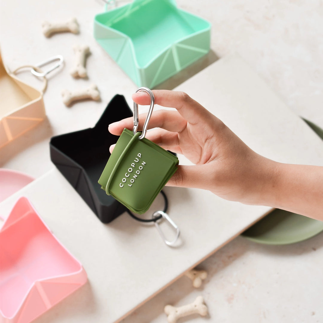 Hand holding a green COCopup LONDON product with a white background