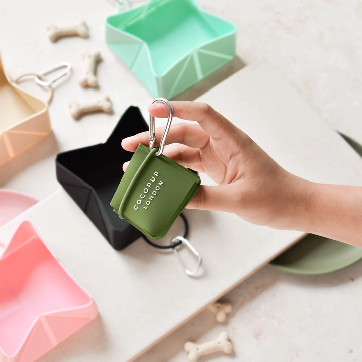 Hand holding a green COCopup LONDON product with a white background