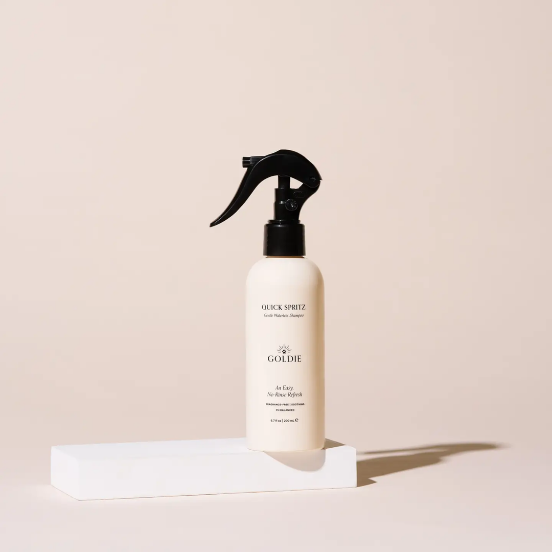 White spray bottle with black nozzle on a beige background