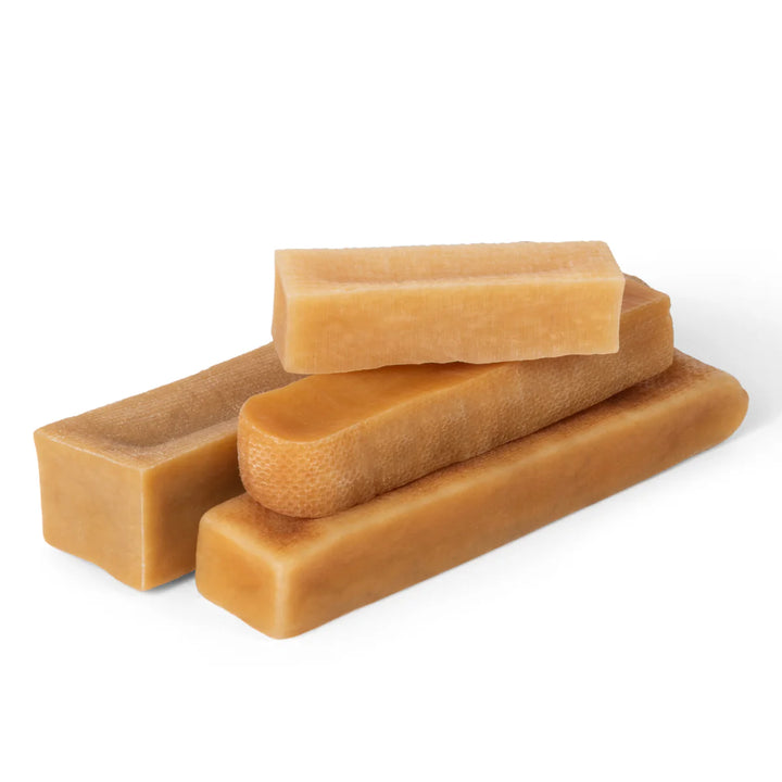 Four rectangular Himalayan yak cheese chew stacked on a white background