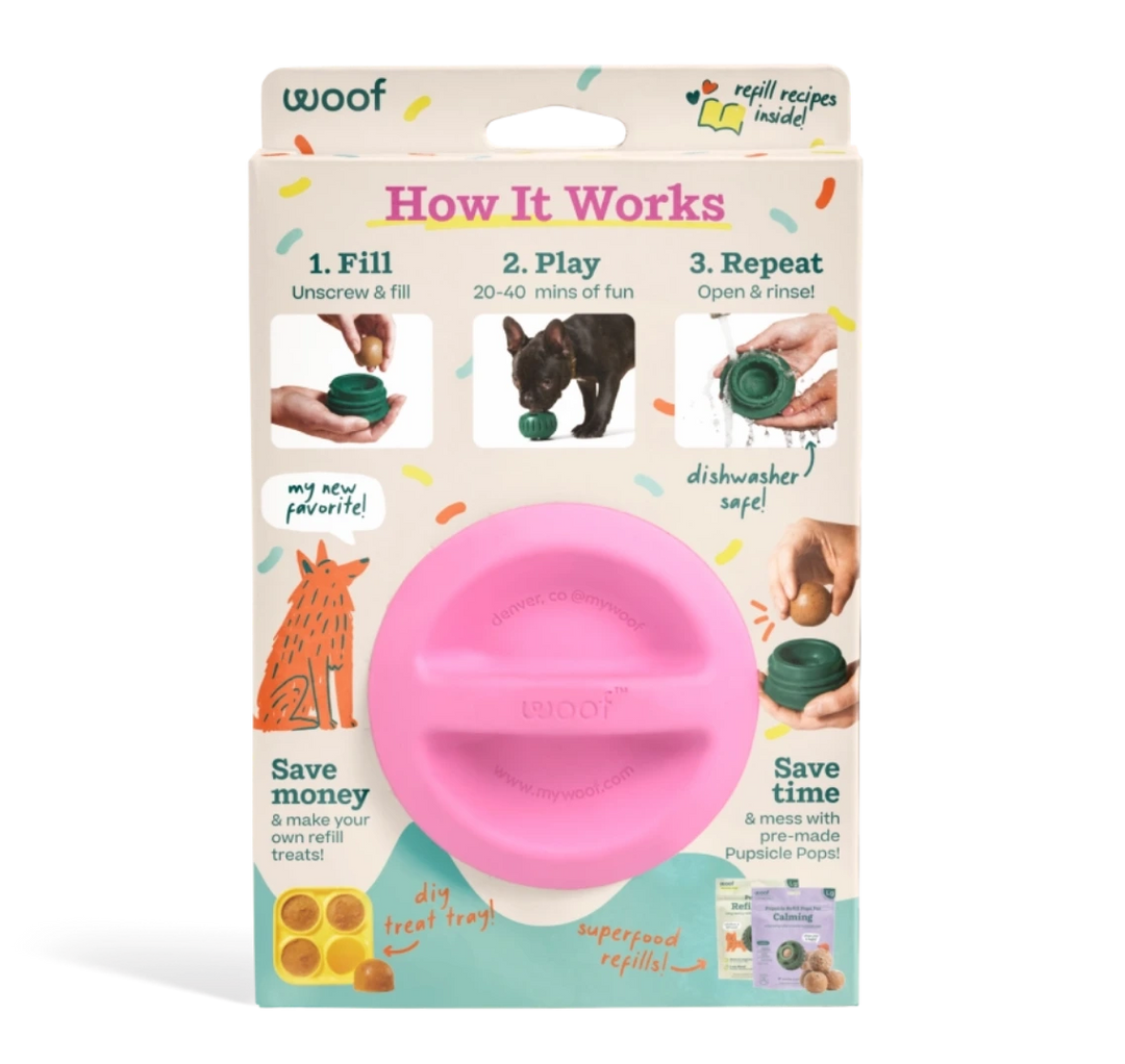 A pink plastic dog toy presented in its retail packaging against a white background. The packaging features the brand name 'woof' and an 'How It Works' diagram explaining how the toy works.