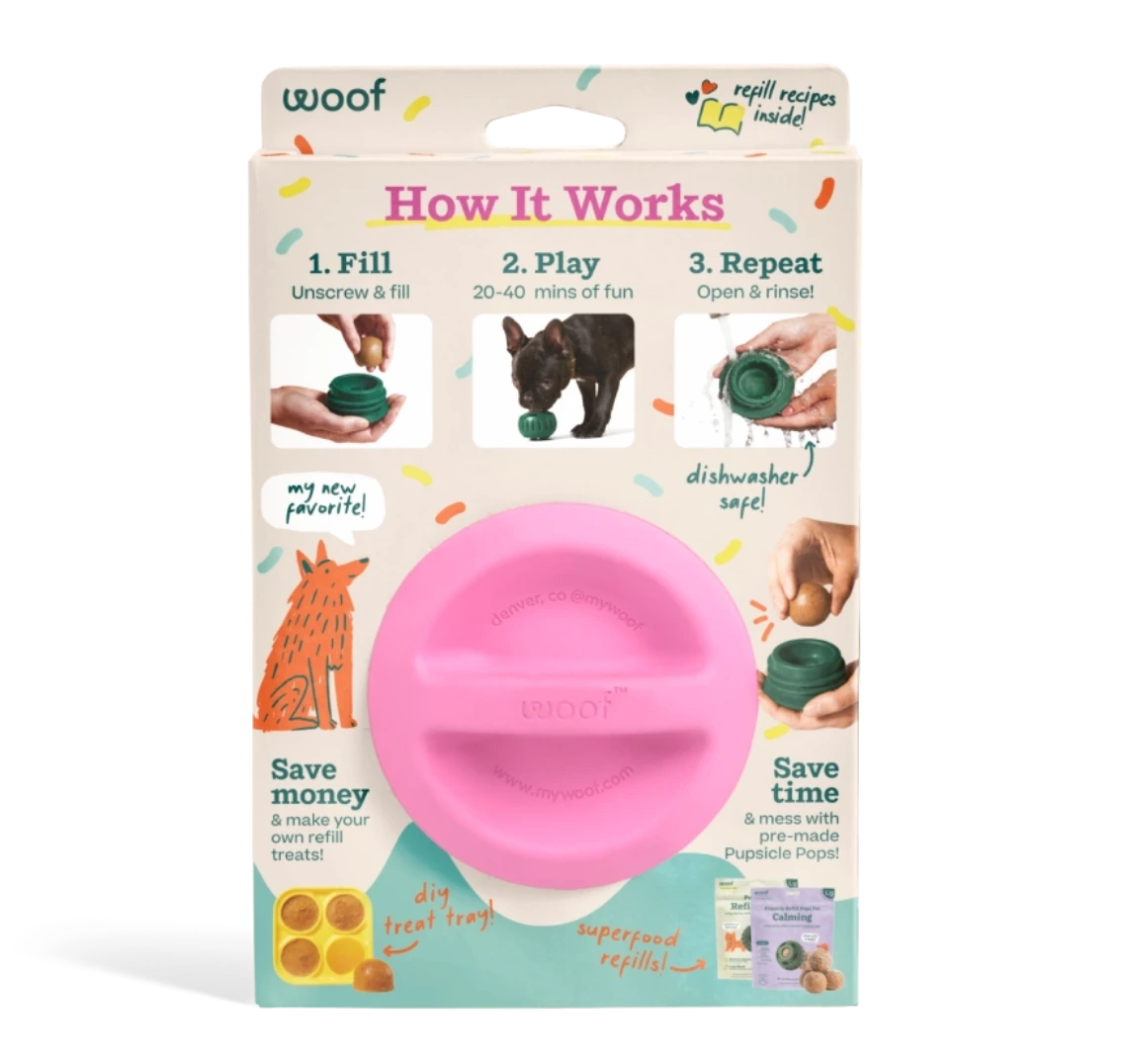 A pink plastic dog toy presented in its retail packaging against a white background. The packaging features the brand name 'woof' and an 'How It Works' diagram explaining how the toy works.