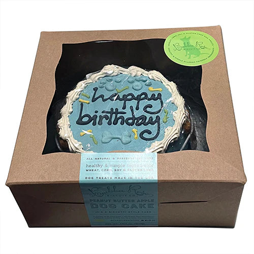 Dog birthday cake in a box with a visible brand label on a white background