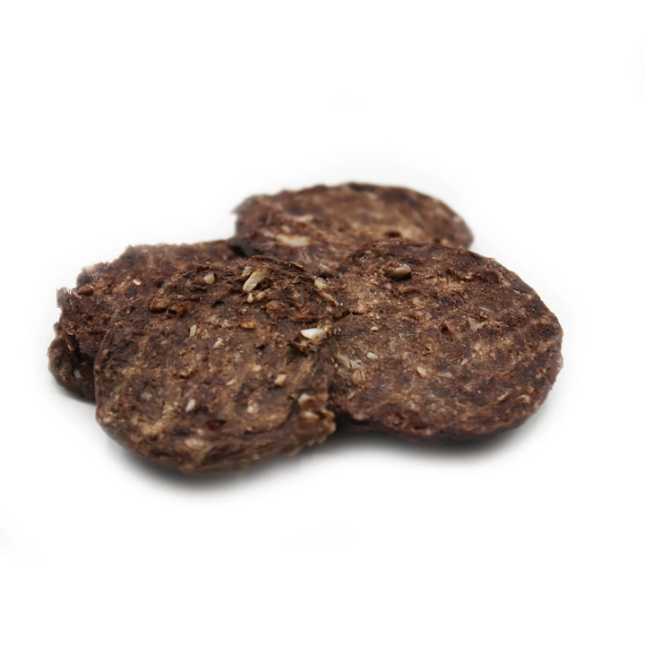 Three dark brown dog treats on a white background