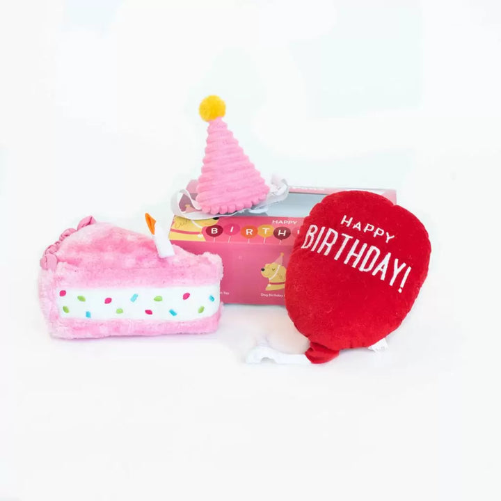 Plush birthday cake and balloon with 'Happy Birthday!' text on a white background