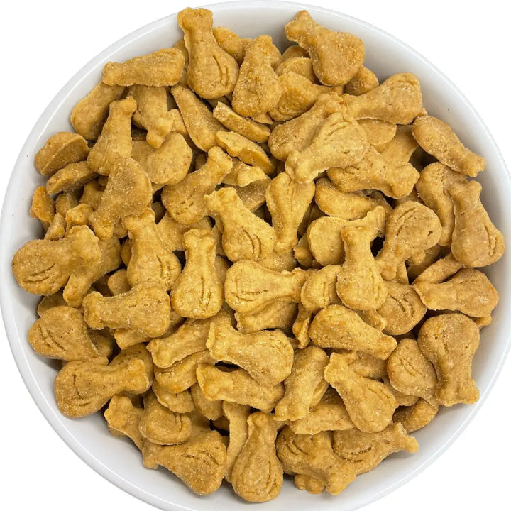Dog treats shaped like bones in a white bowl on a white background