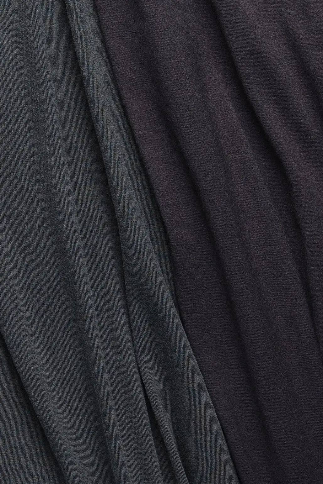 A close-up of draped fabric in two dark charcoal tones, with a subtle sheen and soft folds.